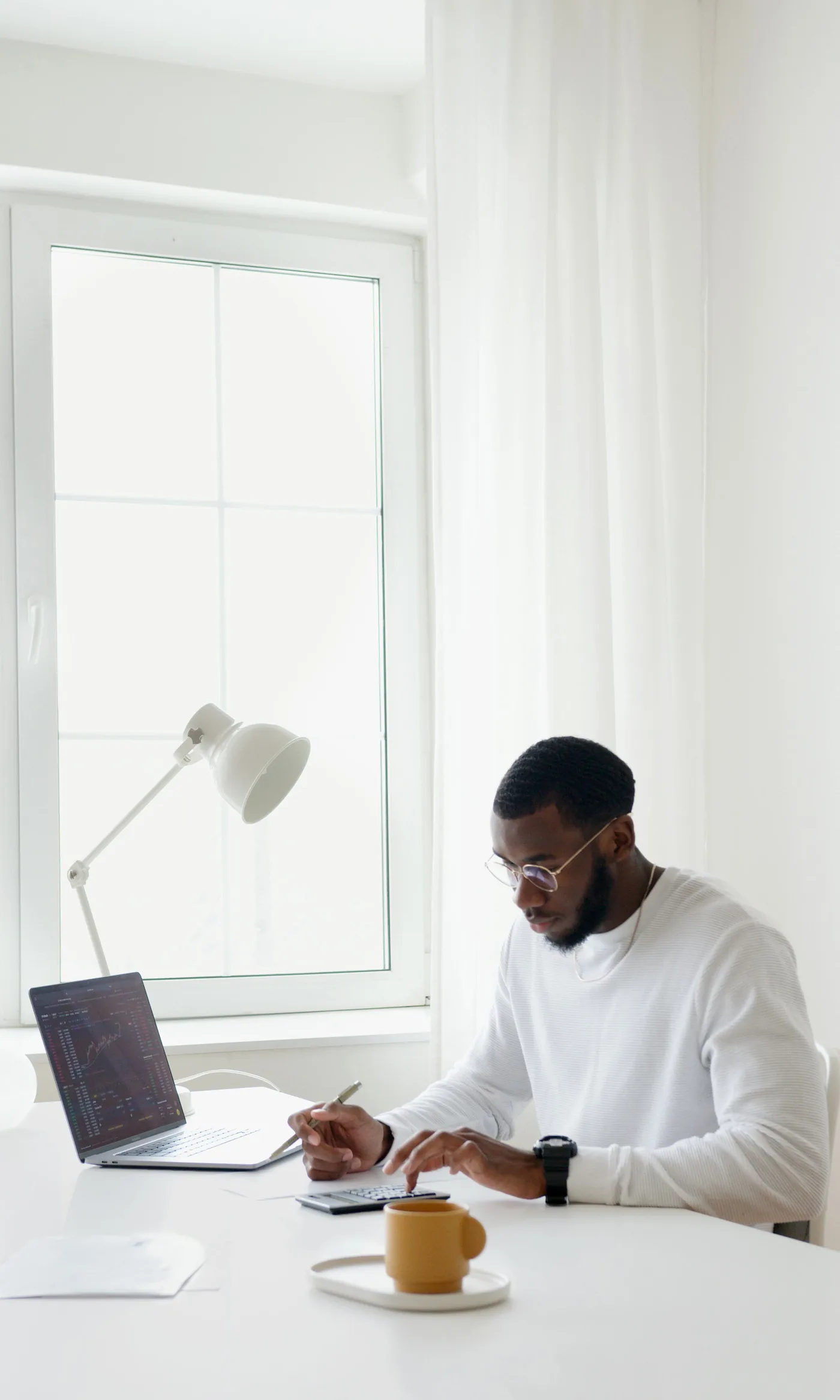 Person reviewing figures with a calculator and laptop